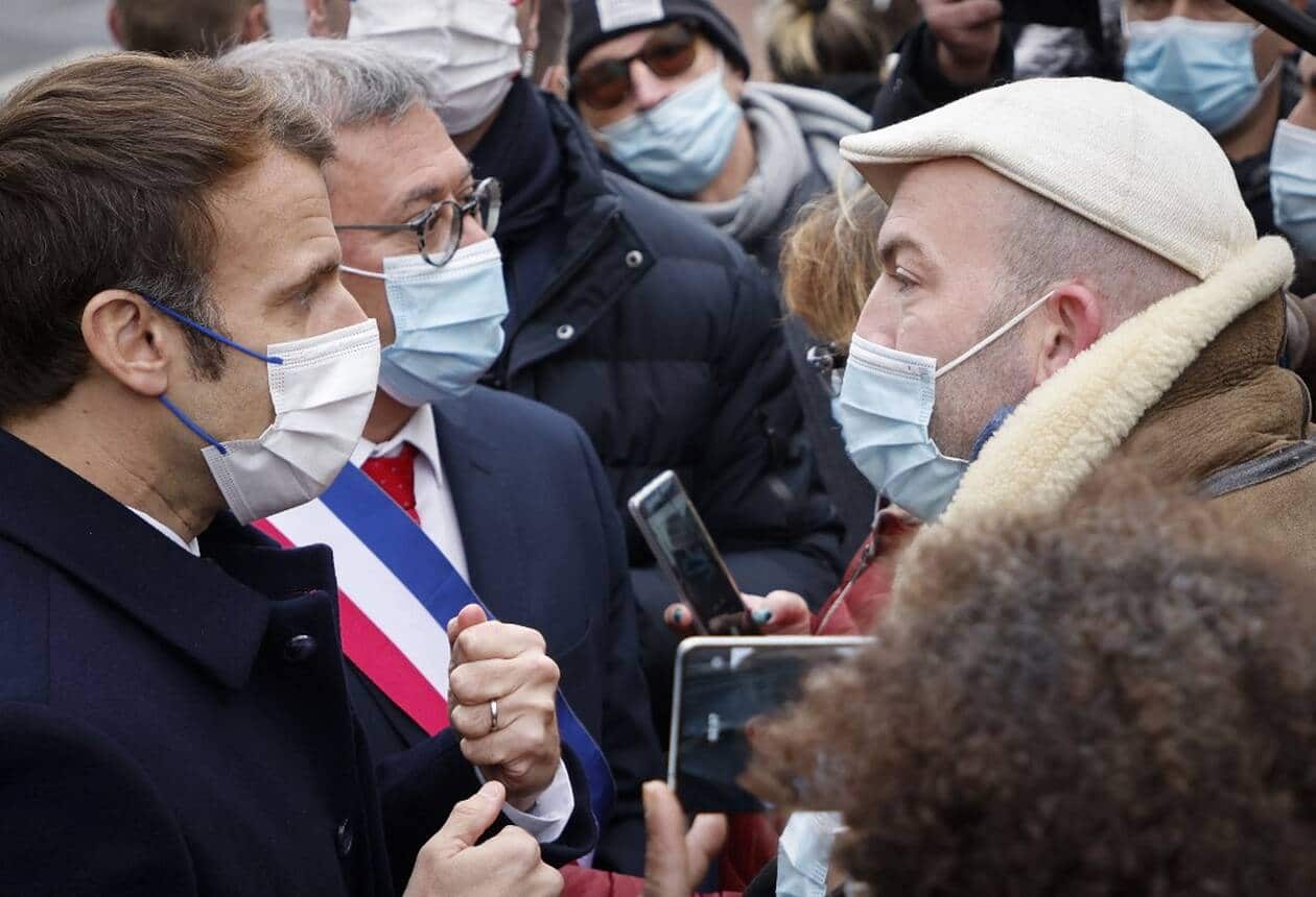 Le président français Emmanuel Macron s'entretient avec le propriétaire d'une boîte de nuit fermée en raison de mesures contre le Covid-19, lors de sa visite dans la ville de Vierzon, Crédit: LUDOVIC MARIN