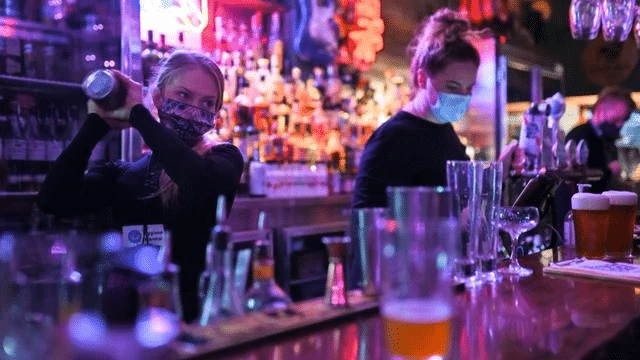 Barmaid préparant un cocktail dans un bar. Crédit : STEVEN SAPHORE / AFP